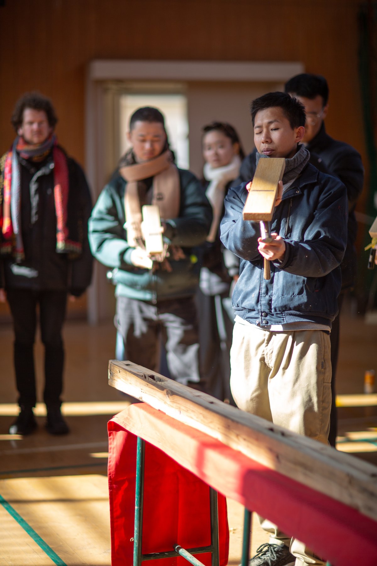 Planing reclaimed wood in the Sunoue Gymnasium, Shikata-led workshop, January 2024 / 志方さん指導の木工ワークショップ、回収材の鉋がけ、須ノ上体育館にて（2024年1月）
